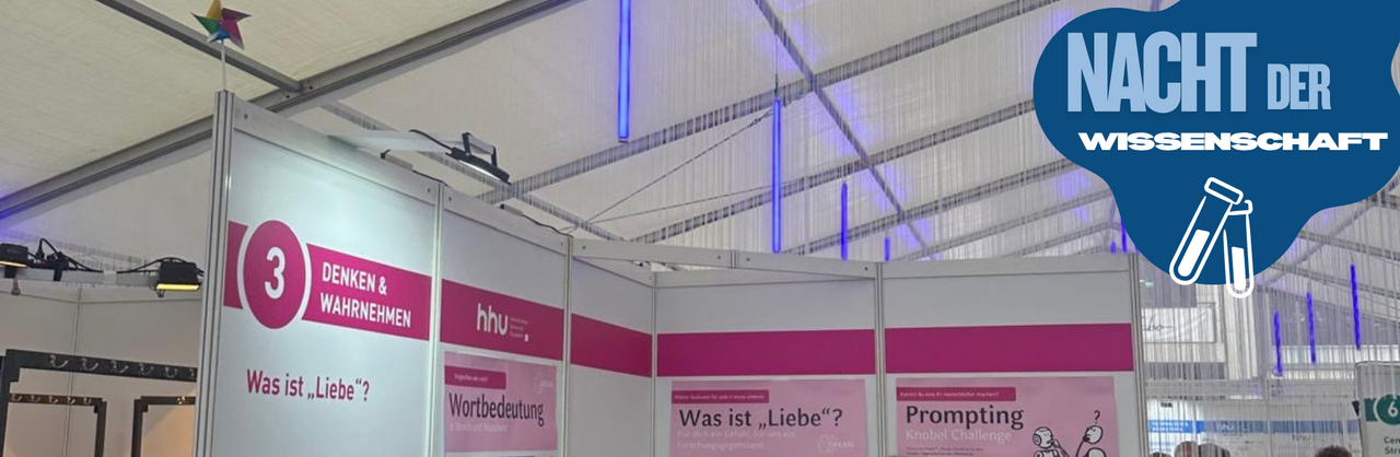 Auf dem Foto sieht den Stand des DREAM-Teams bei der Nacht der Wissenschaft. An den Wänden hängen die Plakate des Teams