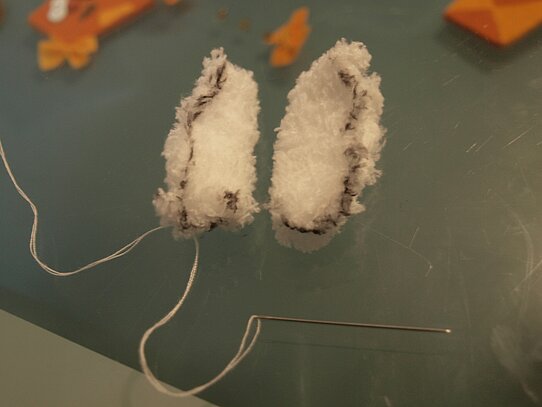 Zwei kleine Ärmchen aus einer Socke geschnitten.