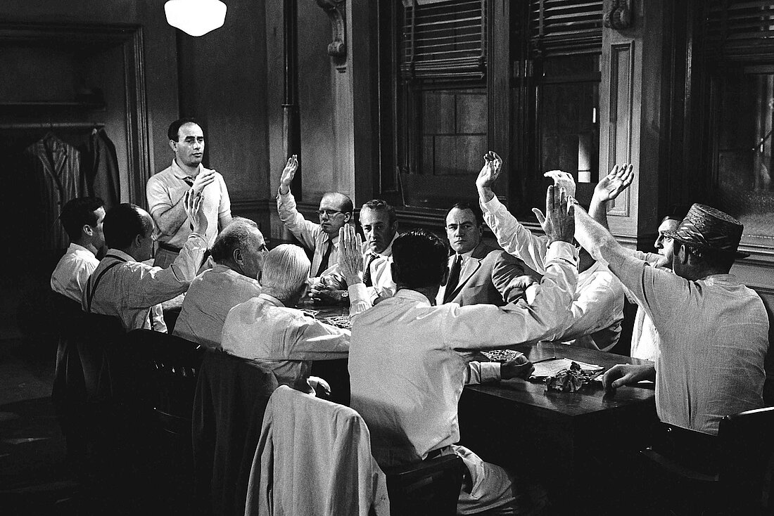 Auf dem Bild sieht man ein Ausschnitt aus dem Film "Die zwölf Geschworenen", mit den 12 Männern am Tisch (Foto:capelight pictures)