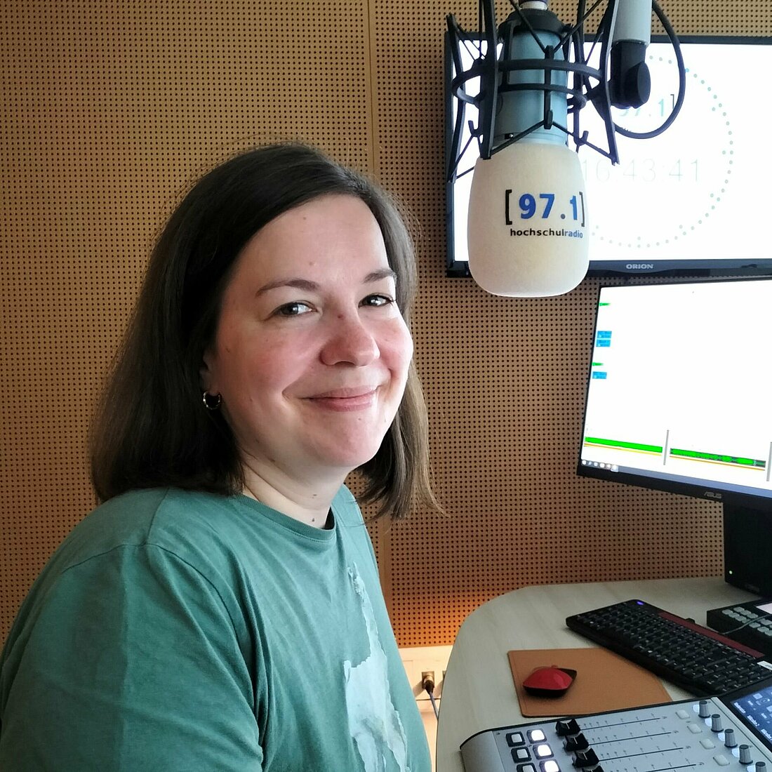 Auf dem Bild ist Katrin Ascani neben einem Mikrofon zu sehen.