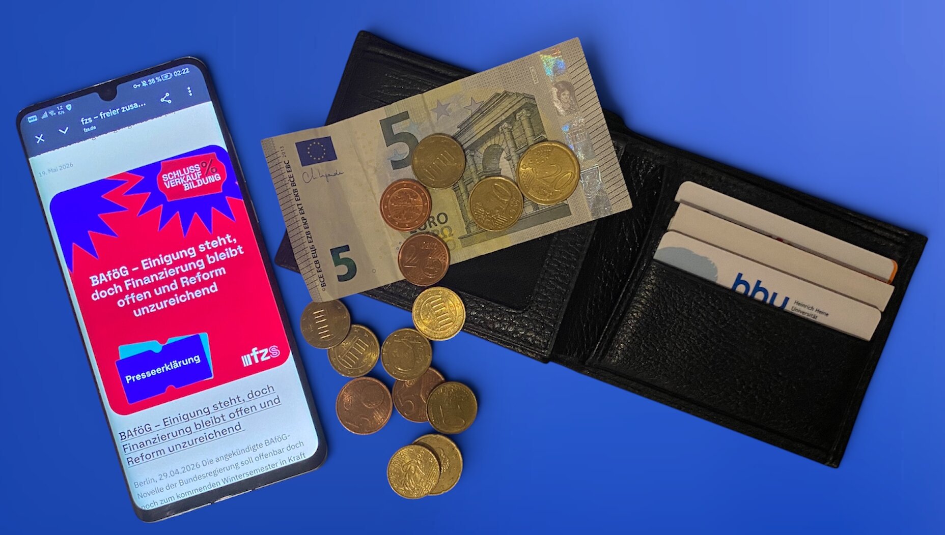 Das Bild zeigt eine Geldbörse, auf der Geld verstreut liegt. Daneben ein Smartphone, auf dem ein Plakat des fzs geöffnet ist.