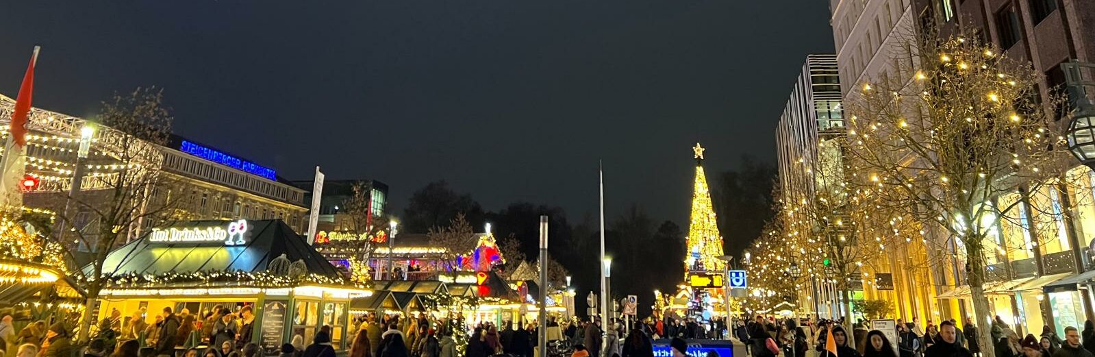 Düsseldorf in der Vorweihnachtszeit. (Foto: Valeska Ridzewski) Auf dem Bild ist ein Weihnachtsmarkt in Düsseldorf zu sehen. Auf dem Bild sind viele Menschen und im Hintergrund ist ein großer Weihnachtsbaum zu erkennen.