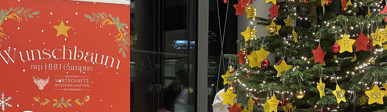 Auf dem Bild sind der Wunschbaum und ein Aufsteller zur Aktion zu sehen.