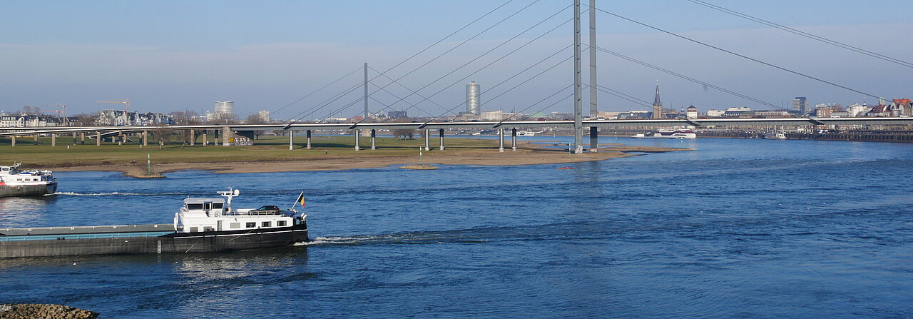 Zu sehen ist der Rhein, mit der Brücke und Düsseldorfs Promenade im Hintergrund