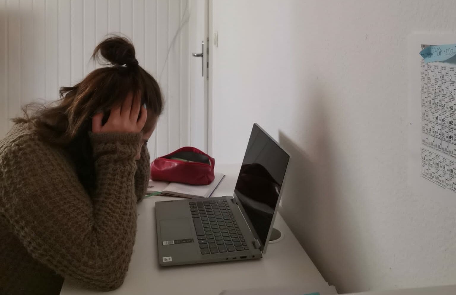 Man sieht eine frustrierte Studierende am Schreibtisch, die sich an den Kopf packt.