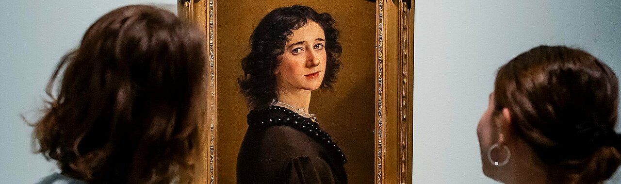 Auf dem Bild sieht man zwei Frauen, die sich das Selbstporträt von Mathilde Dietrichson anschauen (Foto: Anne Orthen)