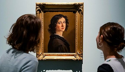 Auf dem Bild sieht man zwei Frauen, die sich das Selbstporträt von Mathilde Dietrichson anschauen (Foto: Anne Orthen)