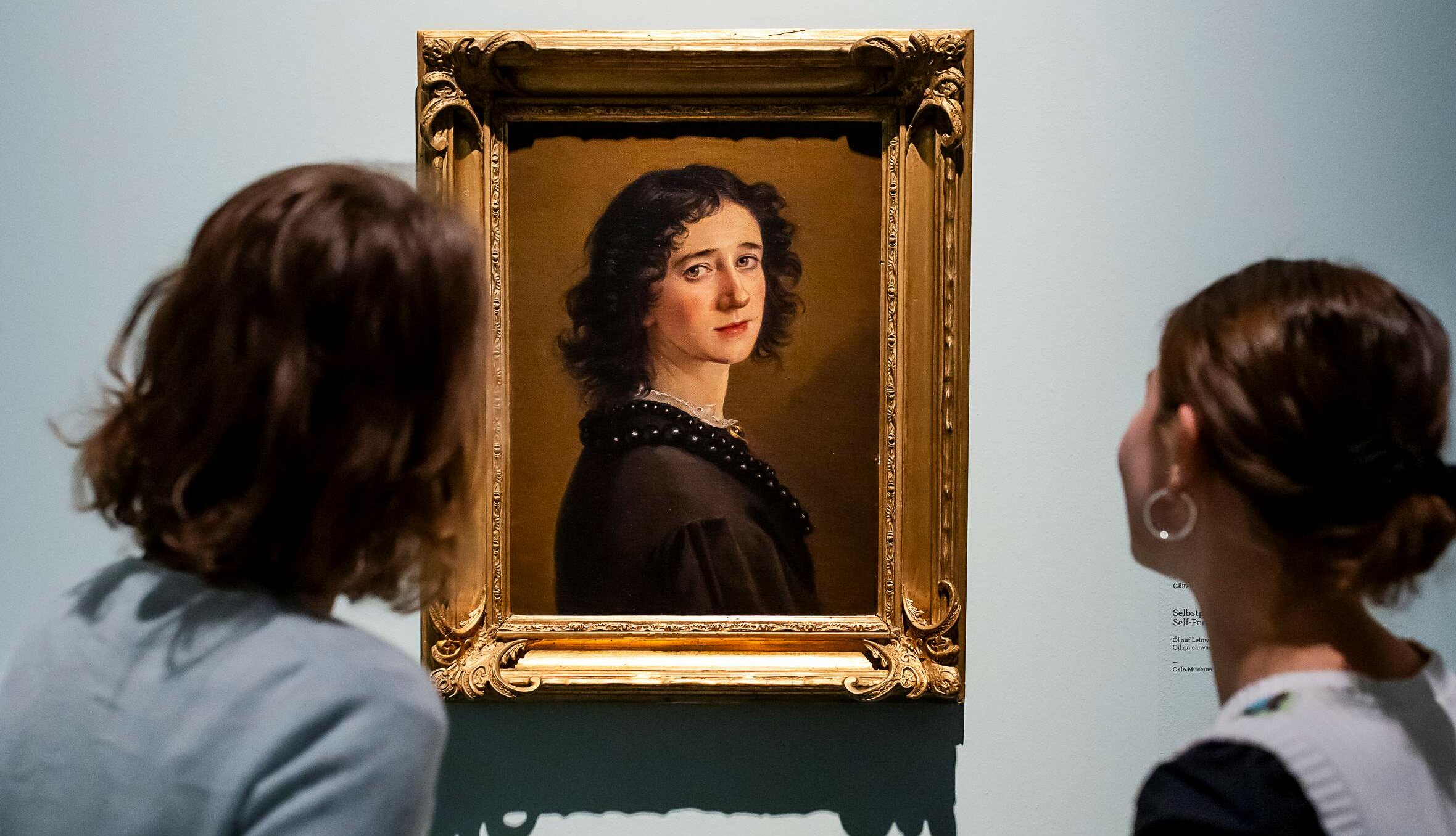 Auf dem Bild sieht man zwei Frauen, die sich das Selbstporträt von Mathilde Dietrichson anschauen (Foto: Anne Orthen)