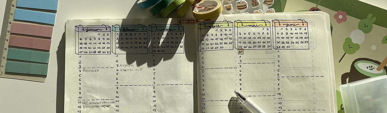 Ein geöffnetes Notizbuch mit Kalender Übersicht