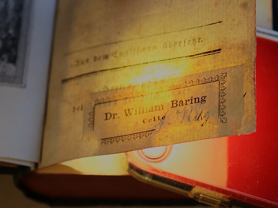 Zu sehen ist ein Buch, unter dessen erster Seite eine Taschenlampe platziert ist. Dadurch ist erkennbar, was auf der Seite steht.
