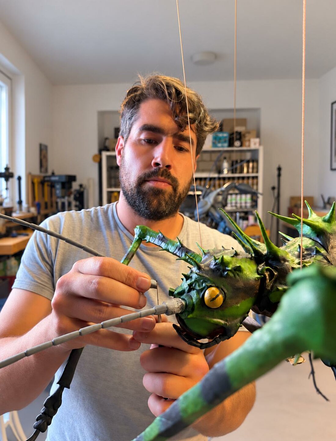 Felix Focke klebt einen Fühler an den Kopf einer Skulptur.