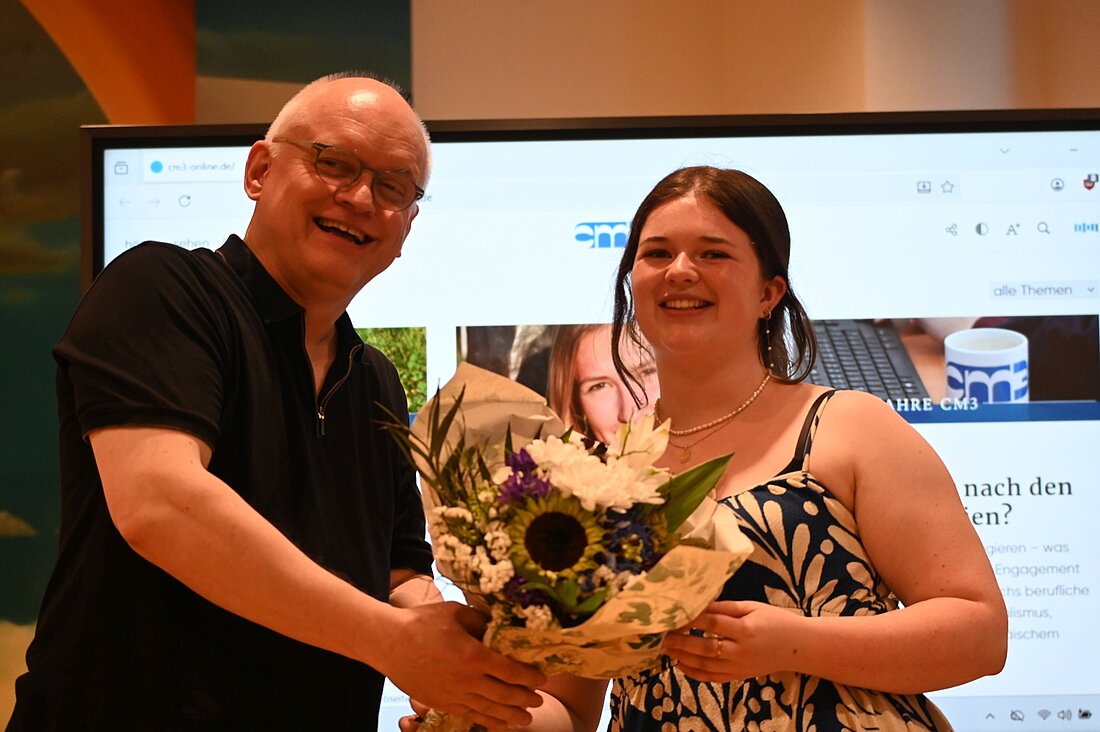 Auf dem Foto sieht man Marie Förder mit Andreas Meske mit einem Blumenstrauß