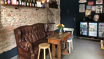Zu sehen ist das Café Covent Garden von innen, mit Blick auf einen Sitzplatz aus einer alten Ledercouch und Bildern an der Wand.