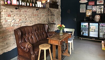 Das Covent Garden Café Zu sehen ist das Café Covent Garden von innen, mit Blick auf einen Sitzplatz aus einer alten Ledercouch und Bildern an der Wand.