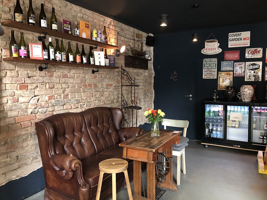 Das Covent Garden Café Zu sehen ist das Café Covent Garden von innen, mit einem Sitzplatz bestehend aus einer alten Ledercouch und einigen Bildern an der Wand.