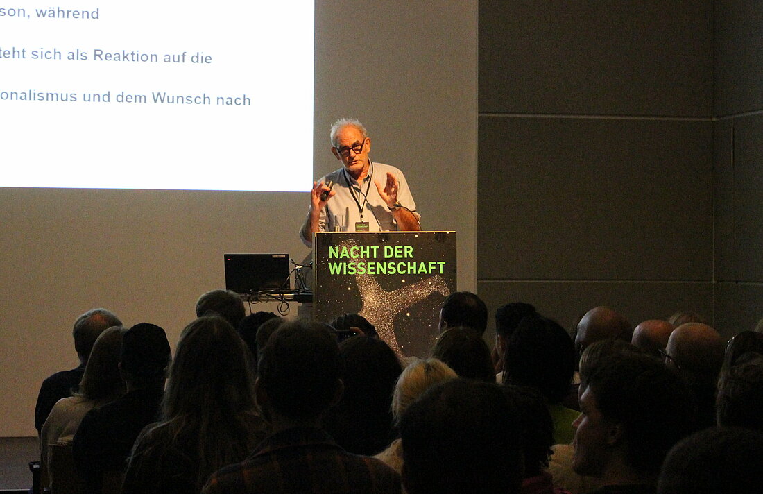 Man sieht Prof. Fabian Virchow am Rednerpult im Haus der Universität.