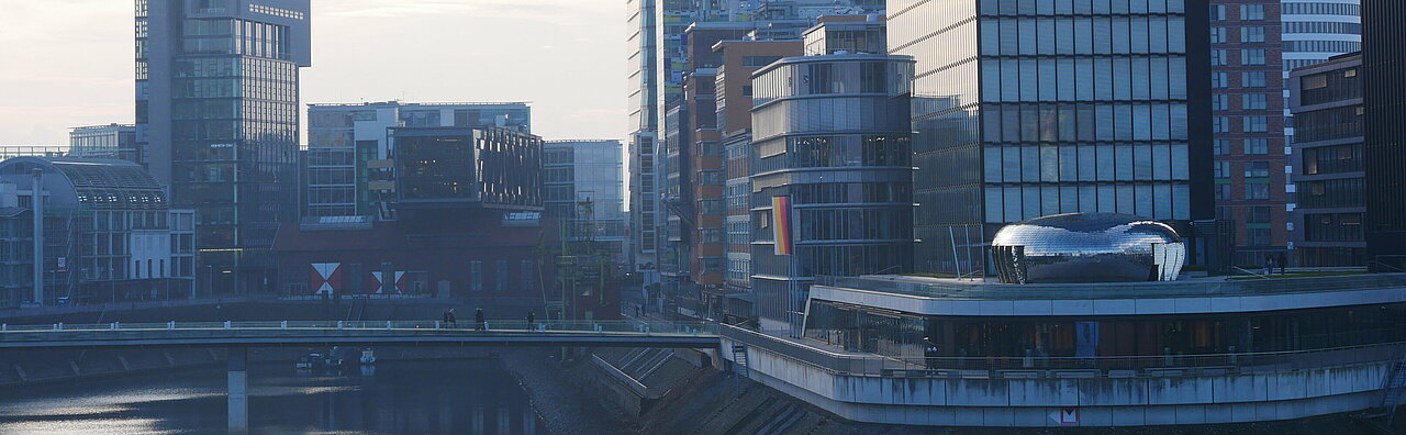 Das Foto zeigt die modernen Gebäude des Medienhafens aus der Sicht der Brücke