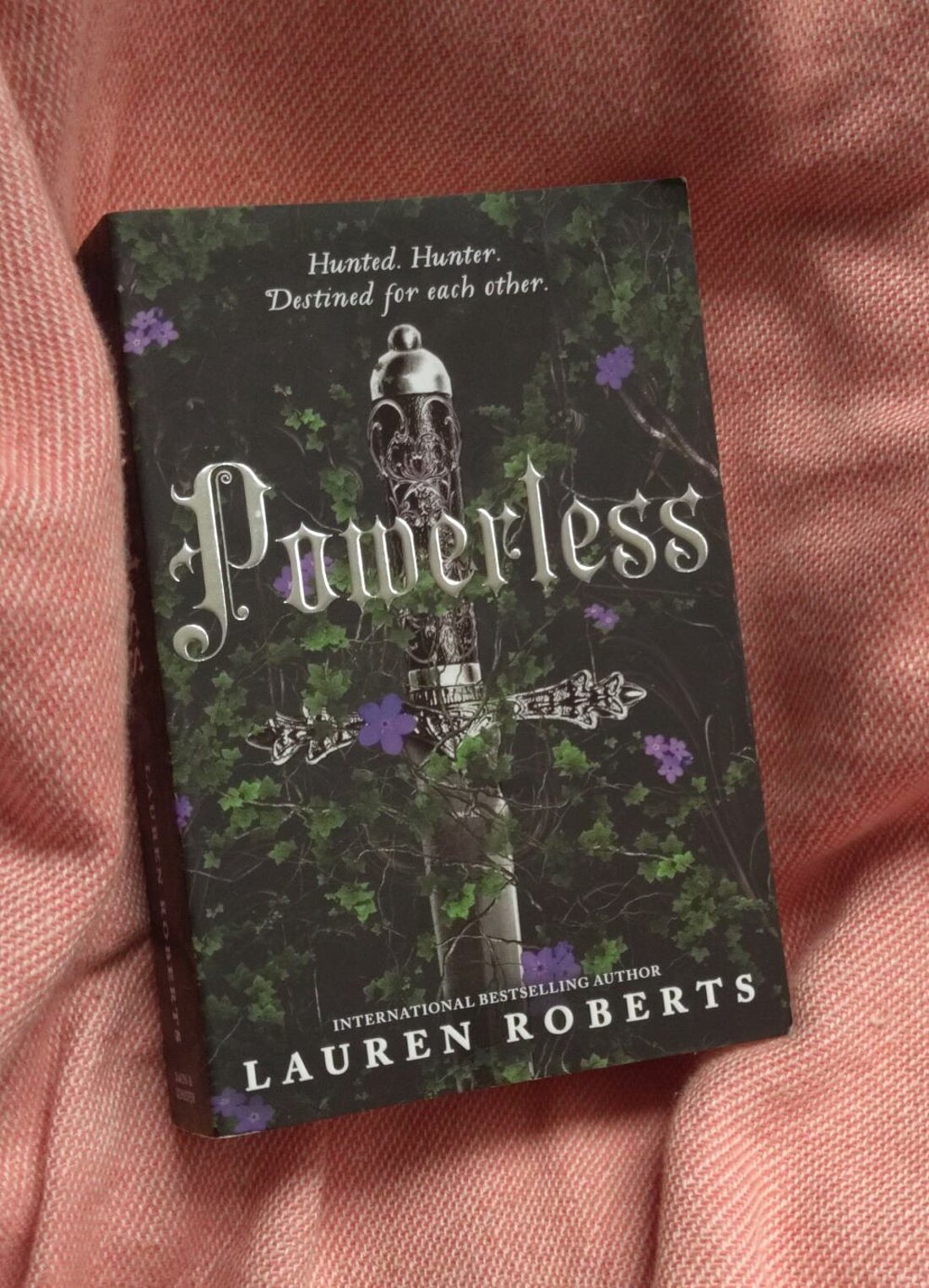 Auf dem Foto ist das Buchcover von Powerless zu sehen. Es ist ein schwarzes Cover und in der Mitte sieht man eine schwarze Säule.