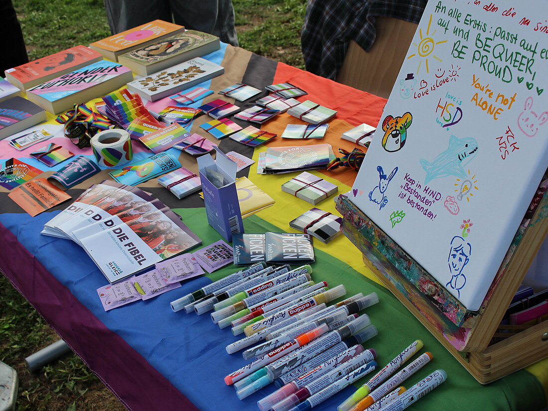 Ein bunter Stand mit verschiedenen Flyern, Sticker und Bücher. 