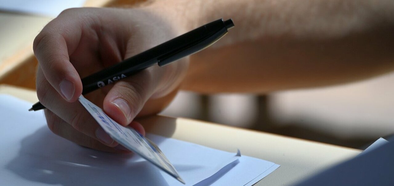 Auf dem Bild sieht man eine Person, die einen Studierendenausweis hält und einen Stift. Es ist im Rahmen der SP-Wahl 2025 entstanden (Foto: Andreas Meske)