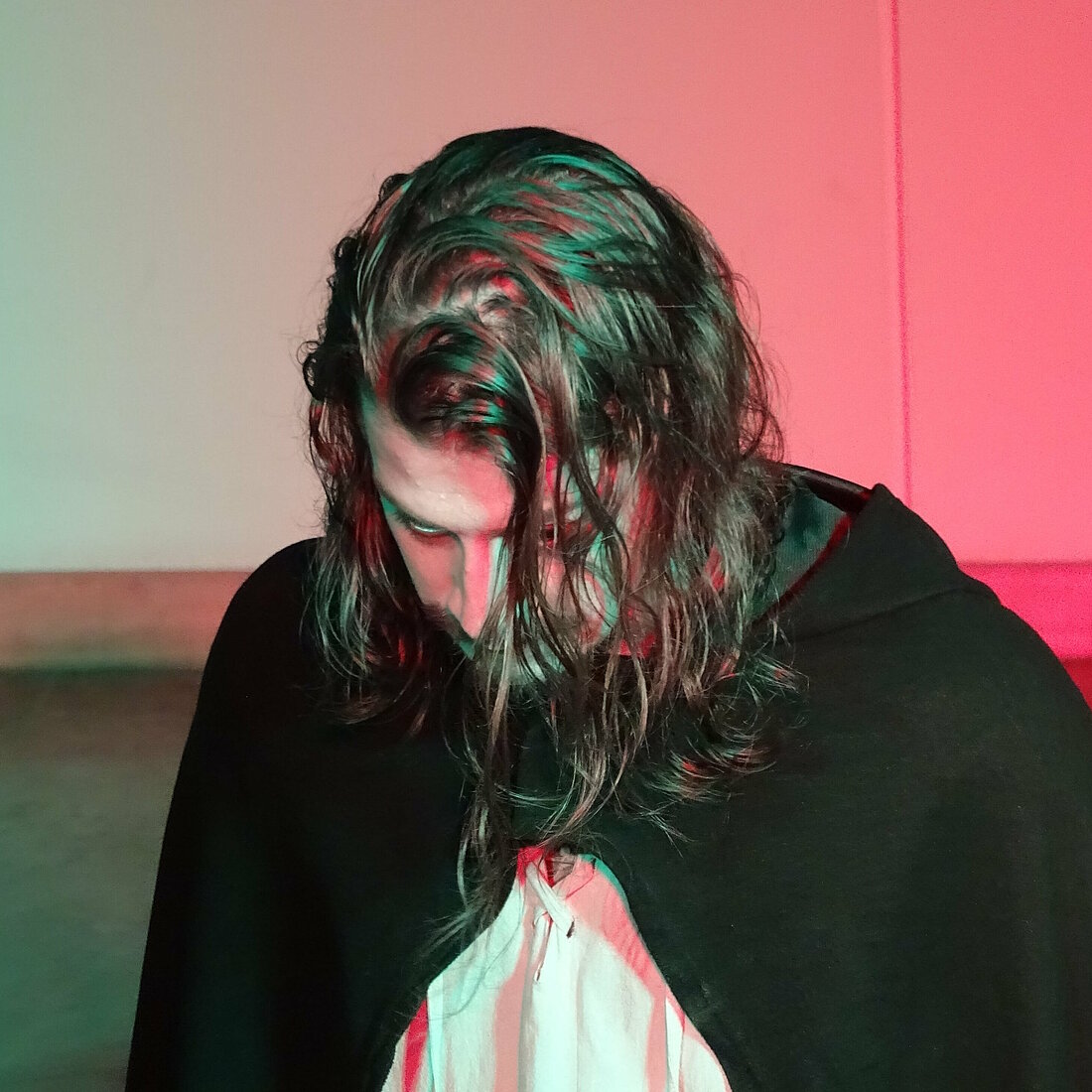 Auf dem Bild ist Arthur Haltrich als Ratti zusehen. Er schaut nach unten und ihm fallen seine Haare ins Gesicht.