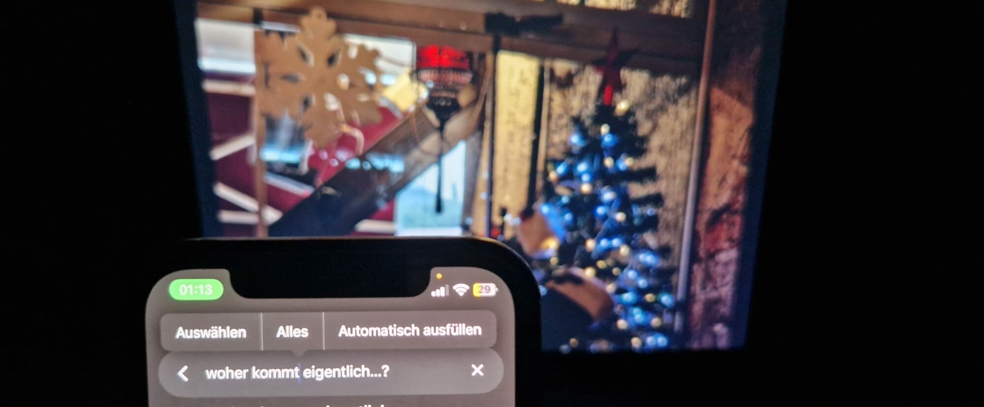 Auf dem Bild sieht man ein Weihnachtsbild im Hintegrund. Vorne sieht man ein Handy, welches bei Google nach Weihnachtsmythen sucht Woher kommen Weihnachtsmythen? (Foto: Asya Nur Kahraman)