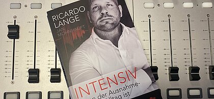 sieht das Buch „Intensiv Wenn der Ausnahmezustand Alltag ist – Ein Notfall“ von Ricardo Lange. Das Buch liegt auf einem digitalen Mischpult.