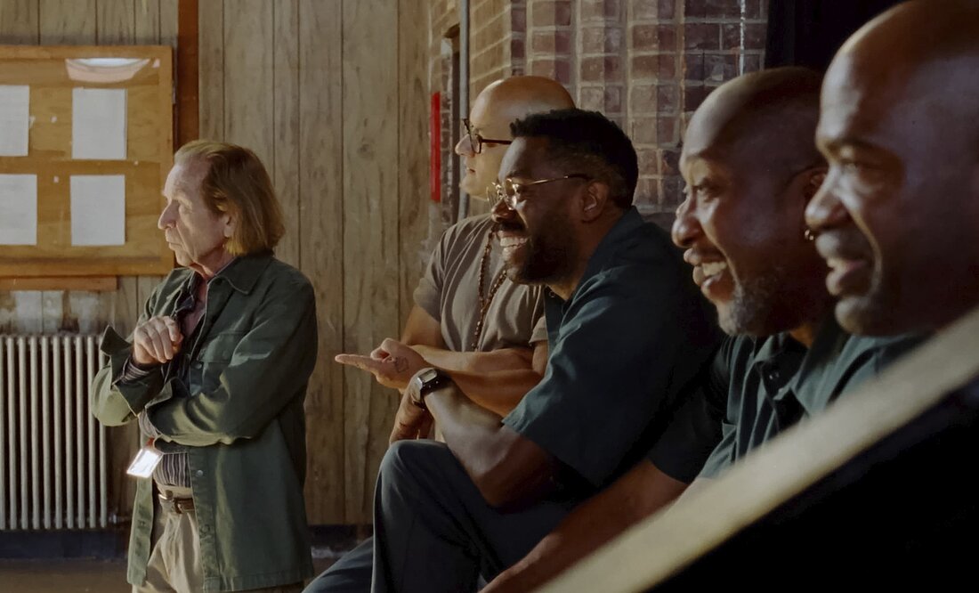 Auf dem Bild sieht man mehrere Gefängnisinsassen die lächelnd nach links gucken (Foto: Kinofilmverleih Weltkino und kommt noch)