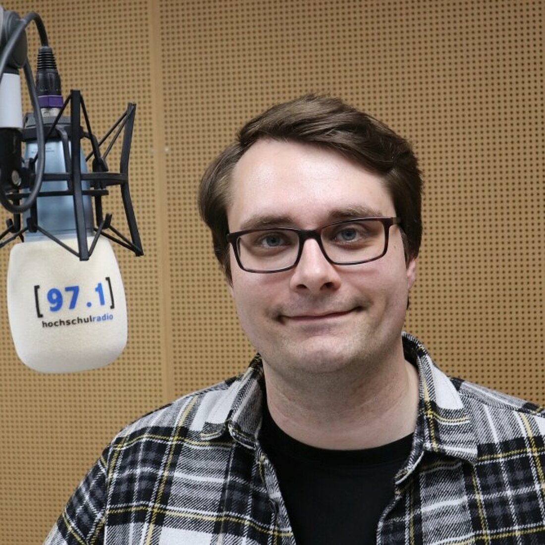 Auf dem Bild ist Tobias Schlemper neben einem Mikrofon zu sehen.