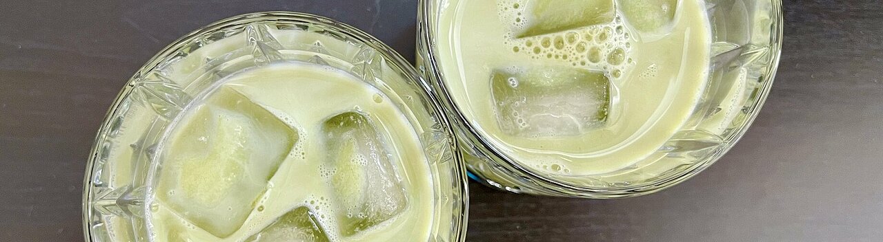 Man sieht zwei Gläser in denen der Grüne Matcha Tee mit Eiswürfeln zusammen ist