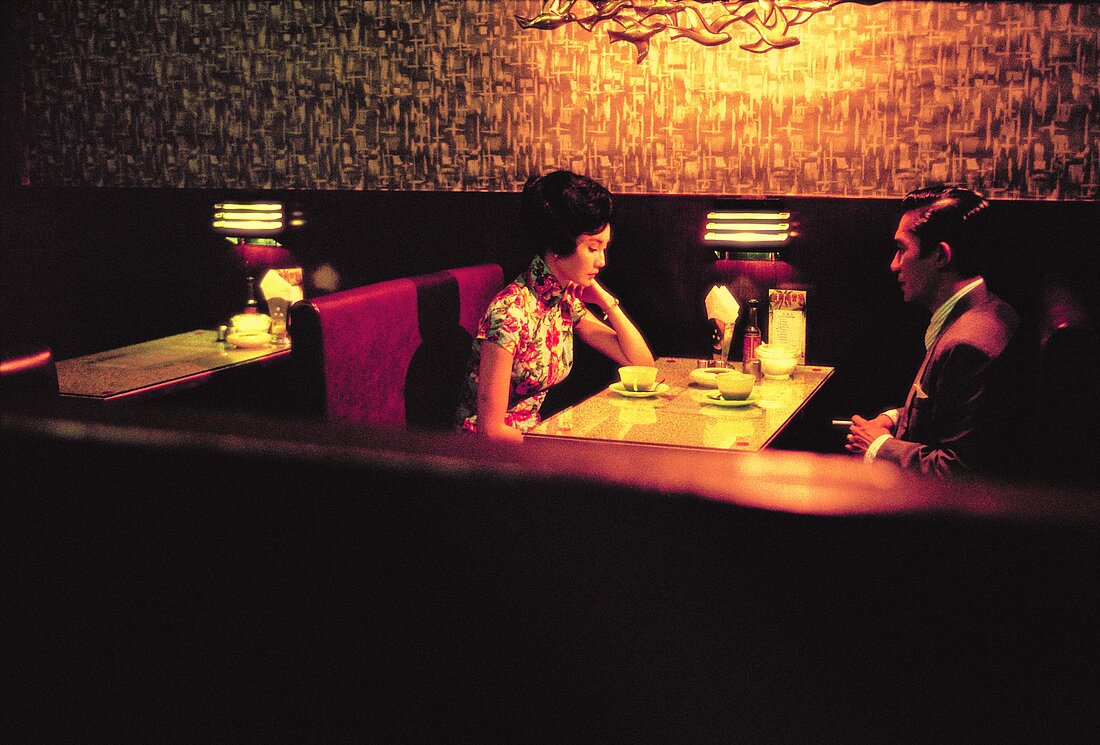 Auf dem Bild sieht man Mrs.Chan und Mr.Chow bei einem Abendessen in akzentuierten Rot-Töne und einer stilvollen Kulisse (Foto: Plaion Picutes)