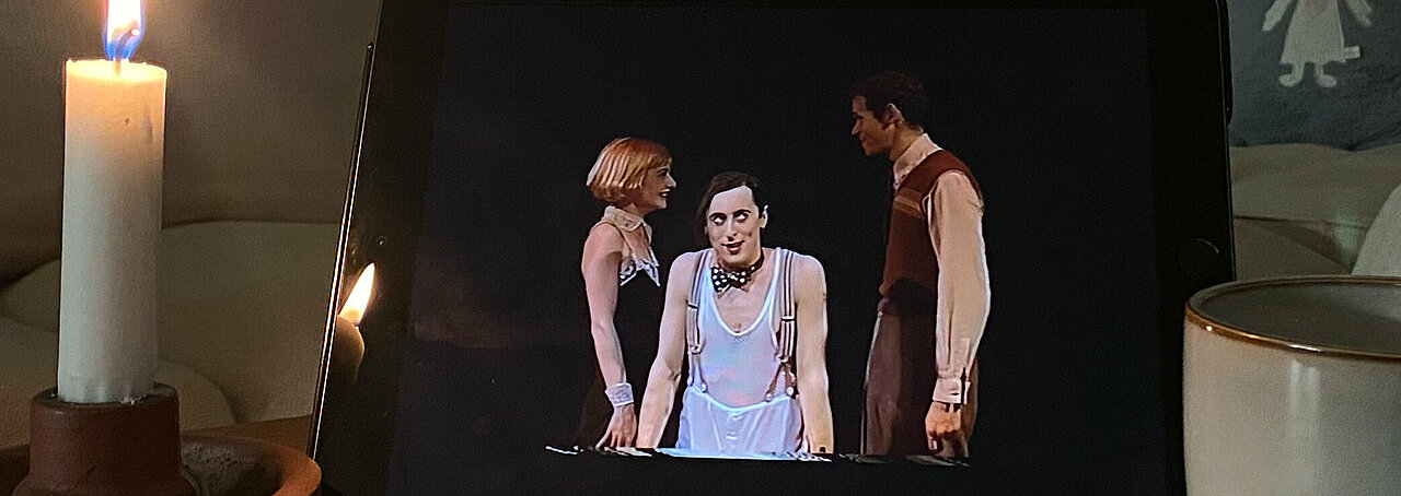 Auf dem Bild sieht man ein Ipad mit dem Musical das Musical „Cabaret“. Daneben steht eine Kerze 