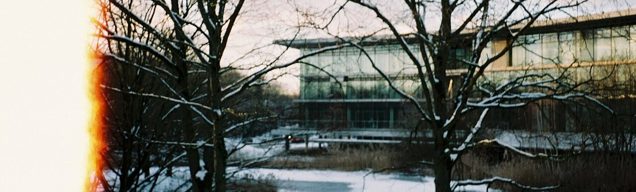 Bild vom Oeconomicum hinter schneebelegten Bäumen