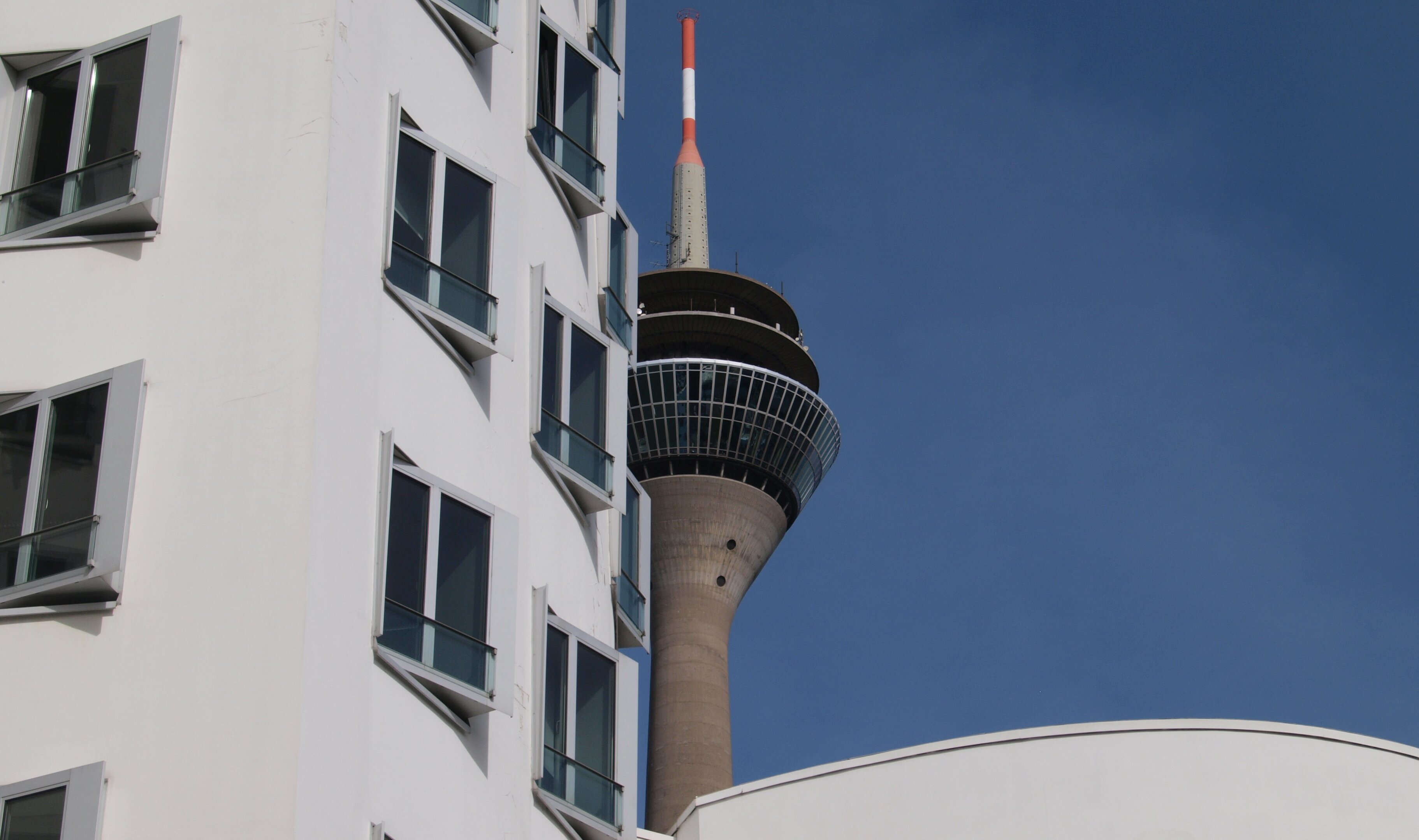 Auf dem Bild sieht man die Gebäude am Medienhafen in Düsseldorf mit Blick auf den Rheinturm bei gutem Wetter(Foto: Michelle Pieczyk)