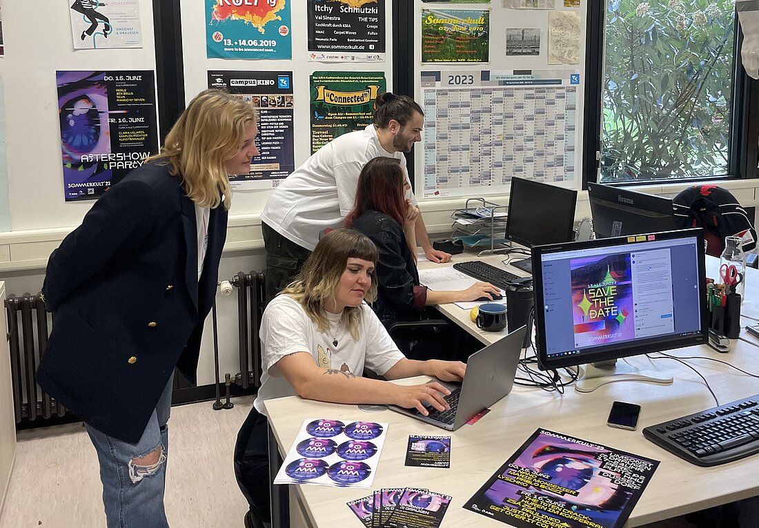 Das Orgateam des Sommerkults im Büro (Foto: Hannes Rudolph) Auf dem Bild sieht man vier Personen, die am Schreibtisch arbeiten