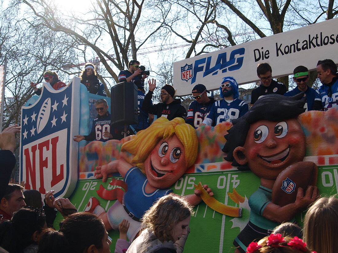 Ein Sport-Mottowagen über die NFL auf welchem Männer in Trikots Süßigkeiten verteilen.