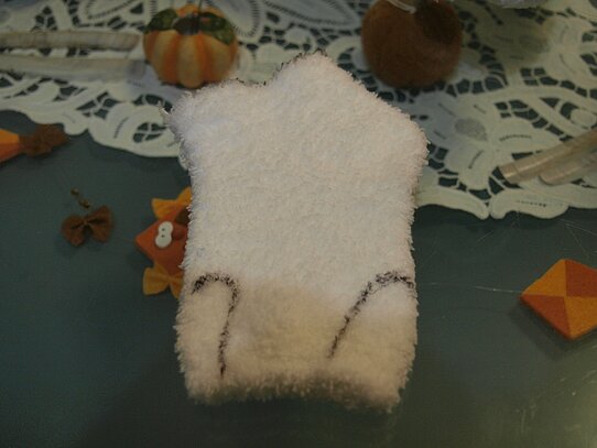 Eine weiße Socke auf der zwei kleine Arme eingezeichnet sind.