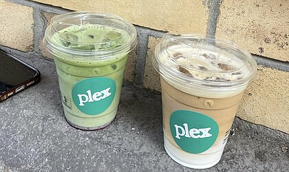 Auf dem Bild sieht man einen Becher mit Iced Bluberry Matcha und einen Becher mit Iced Latte von Plex Coffee