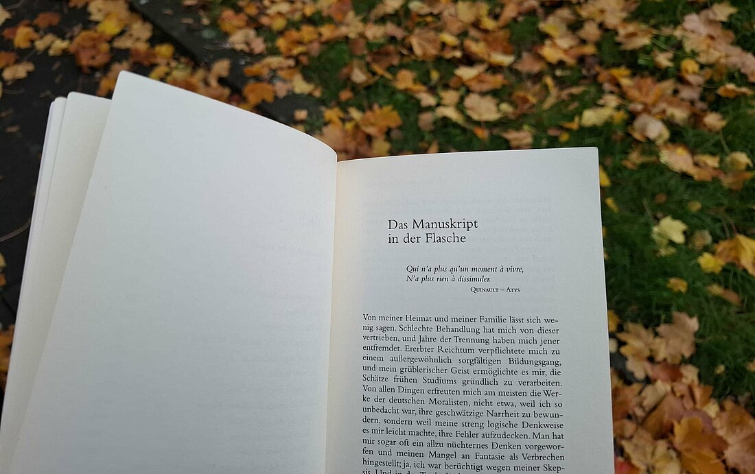 Auf dem Bild sieht man eine Seite aus dem Werk von Edgar Allan Poe. Das Bild ist draußen im Herbst gemacht (Foto:Lisa Omenzetter)