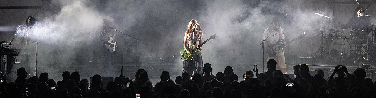 Auf dem Foto sieht man die Band "Wet Leg" auf der Bühne, mit vielen Lichtern und jubelnden Fans davor (Foto:Reiner Pfisterer)