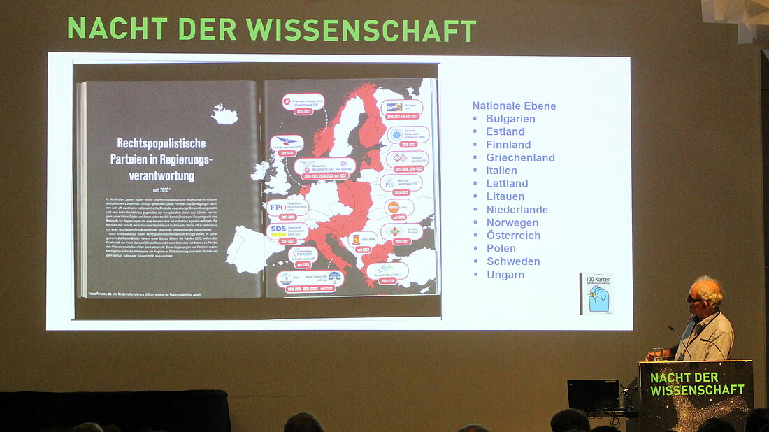 an sieht Prof. Dr. Fabian Virchow am Rednerpult vor der Projektion einer Europa-Karte zu rechtspopulistischen Parteien in Regierungsverantwortung.