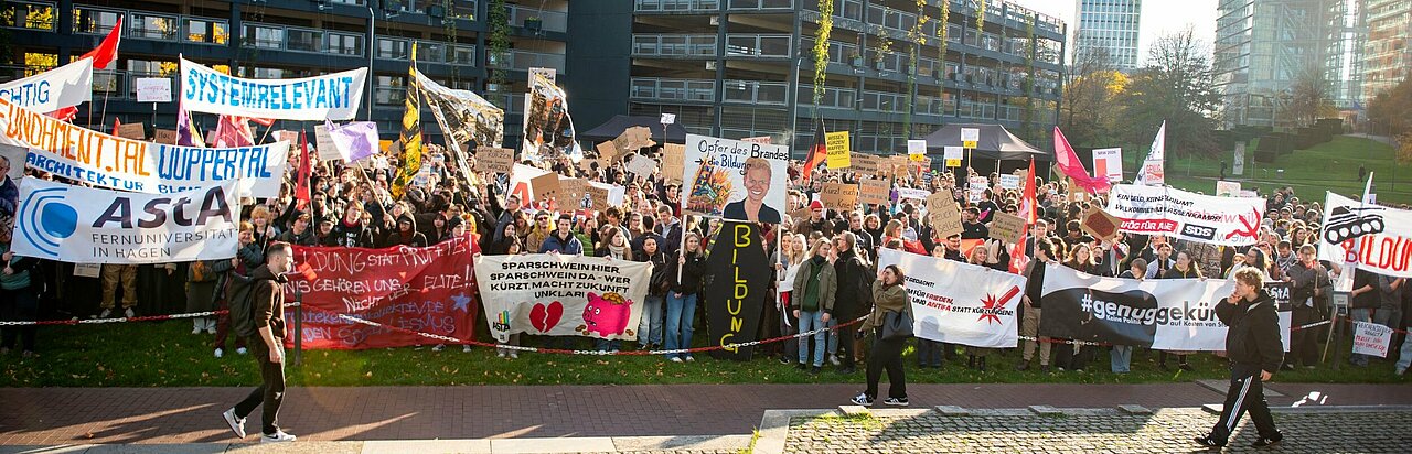 Auf dem Foto sind Demonstrierende zu sehen. Sie halten Banner und Plakate hoch