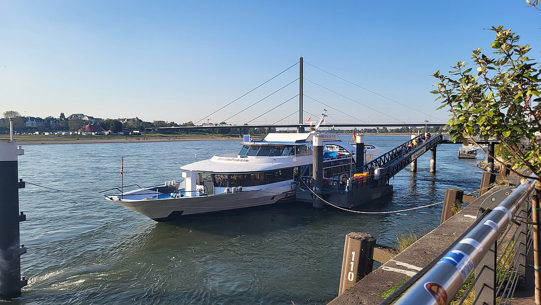 Auf dem Foto befindet sich das Schiff MS RheinPoesie am Anlegeplatz an der Altstadt.
