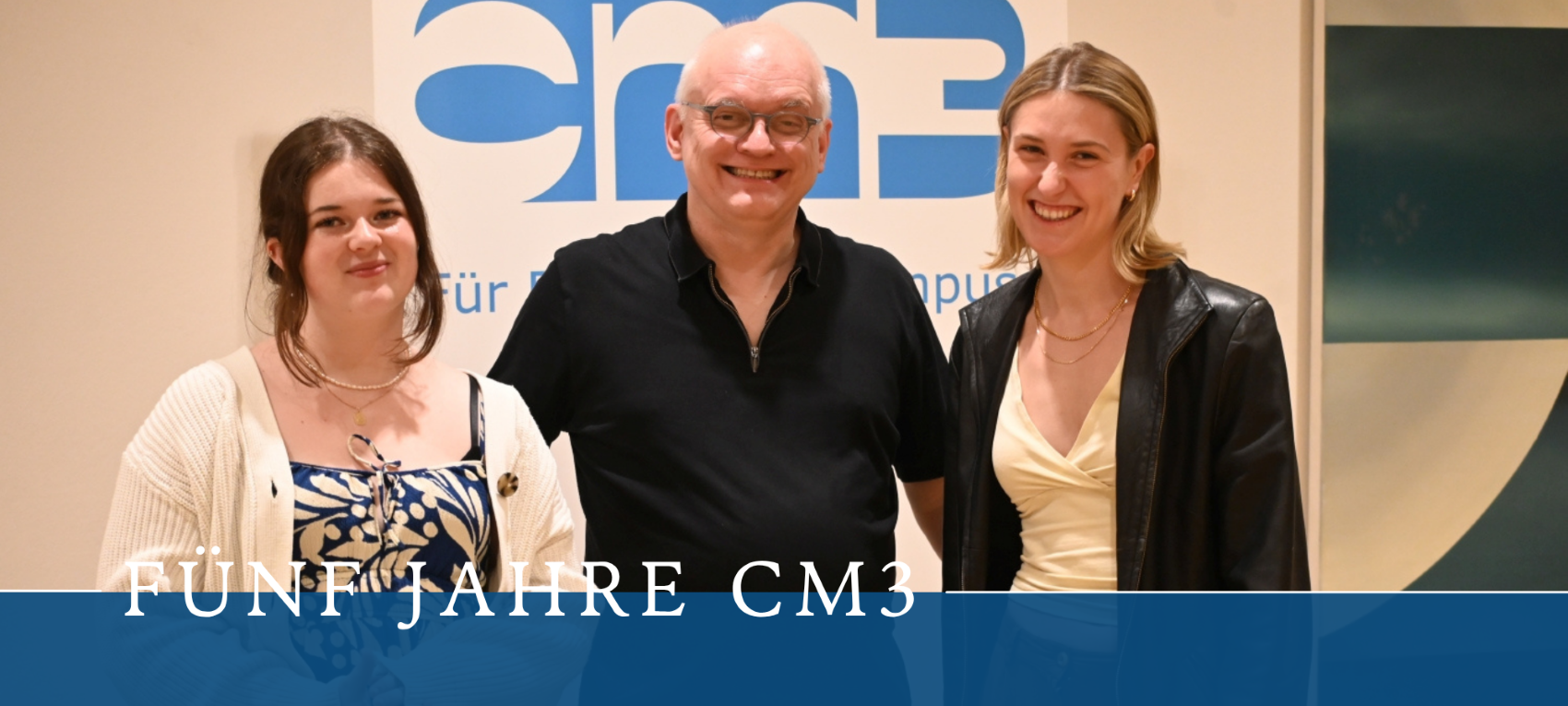 Auf dem Foto sieht man Marie Förder, Andreas Meske und Theresa Schültken die nebeneinander stehen bei der Feier zu 5 Jahre cm3