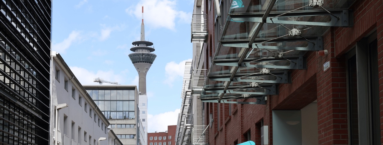 Der Rheinturm in Düsseldorf und Gebäude im Medienhafen.