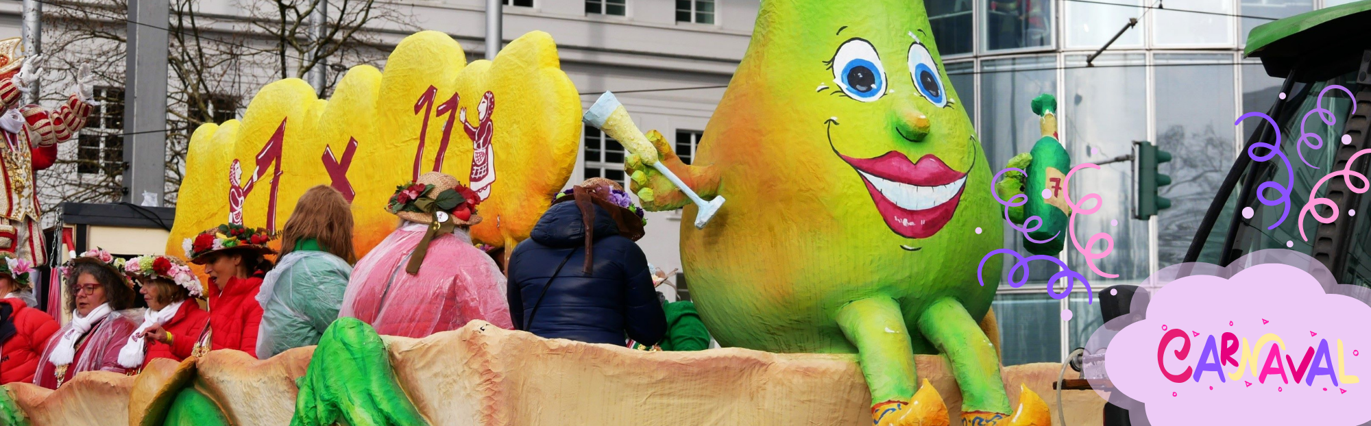 Auf dem Foto sieht man einen Umzugswagen an Rosenmontag in Düsseldorf mit einer lächelnden Birne, die ein Sektglas hält. Darauf sitzen verkleidetet Menschen (Foto: Maylea Selisch)