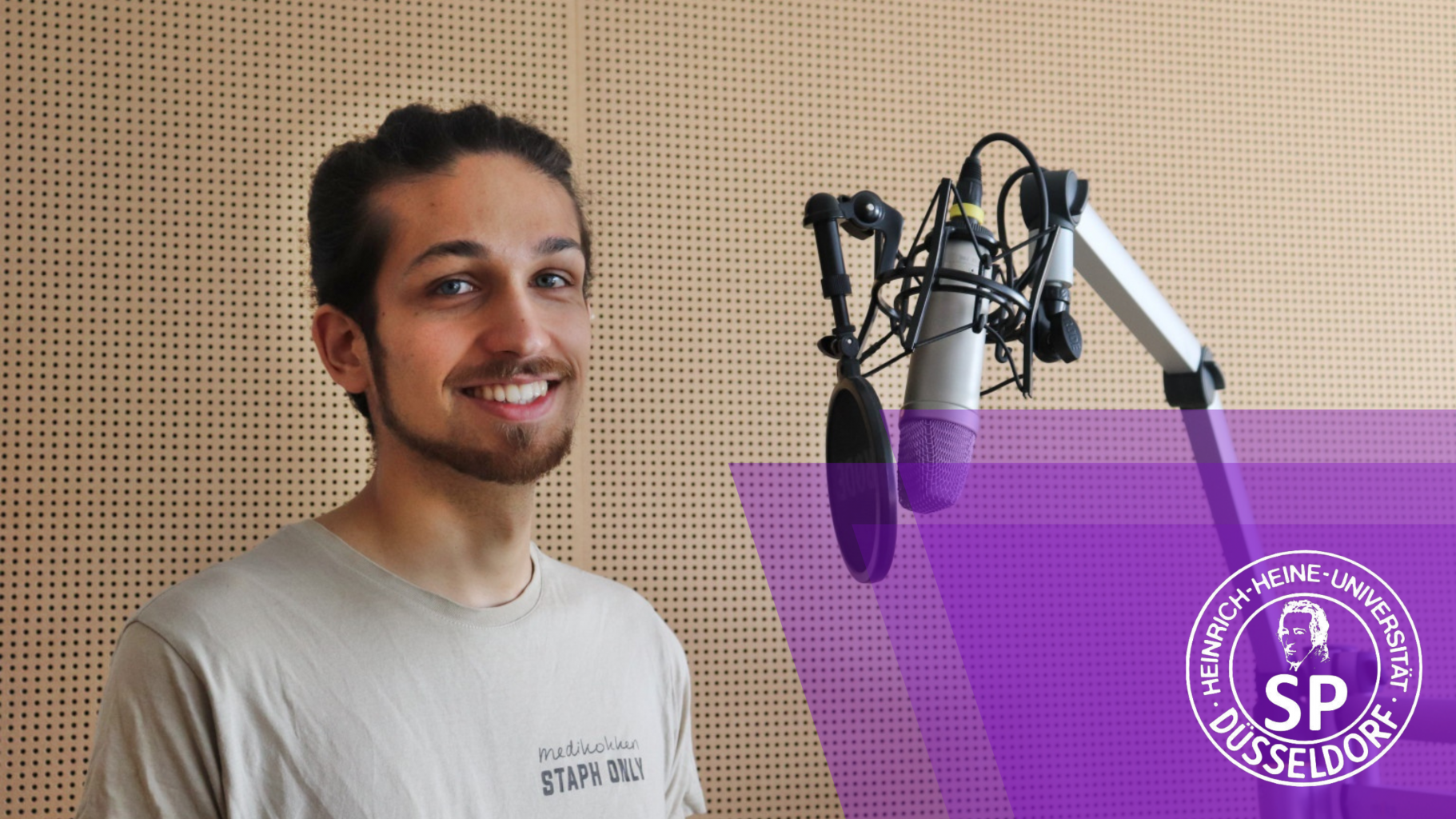 Nabik Syed (CampusGrün) steht beim Interview vor einem Mikrofon im Studio von hochschulradio düsseldorf.
