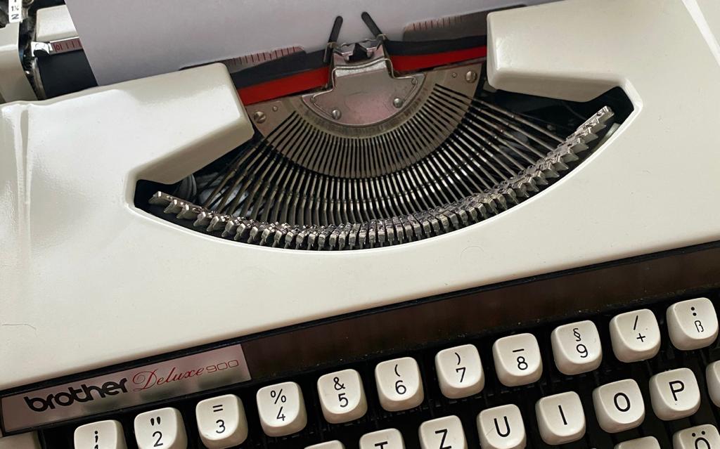 Man sieht eine alte Schreibmaschine mit einem eingezogenem  Blatt. 