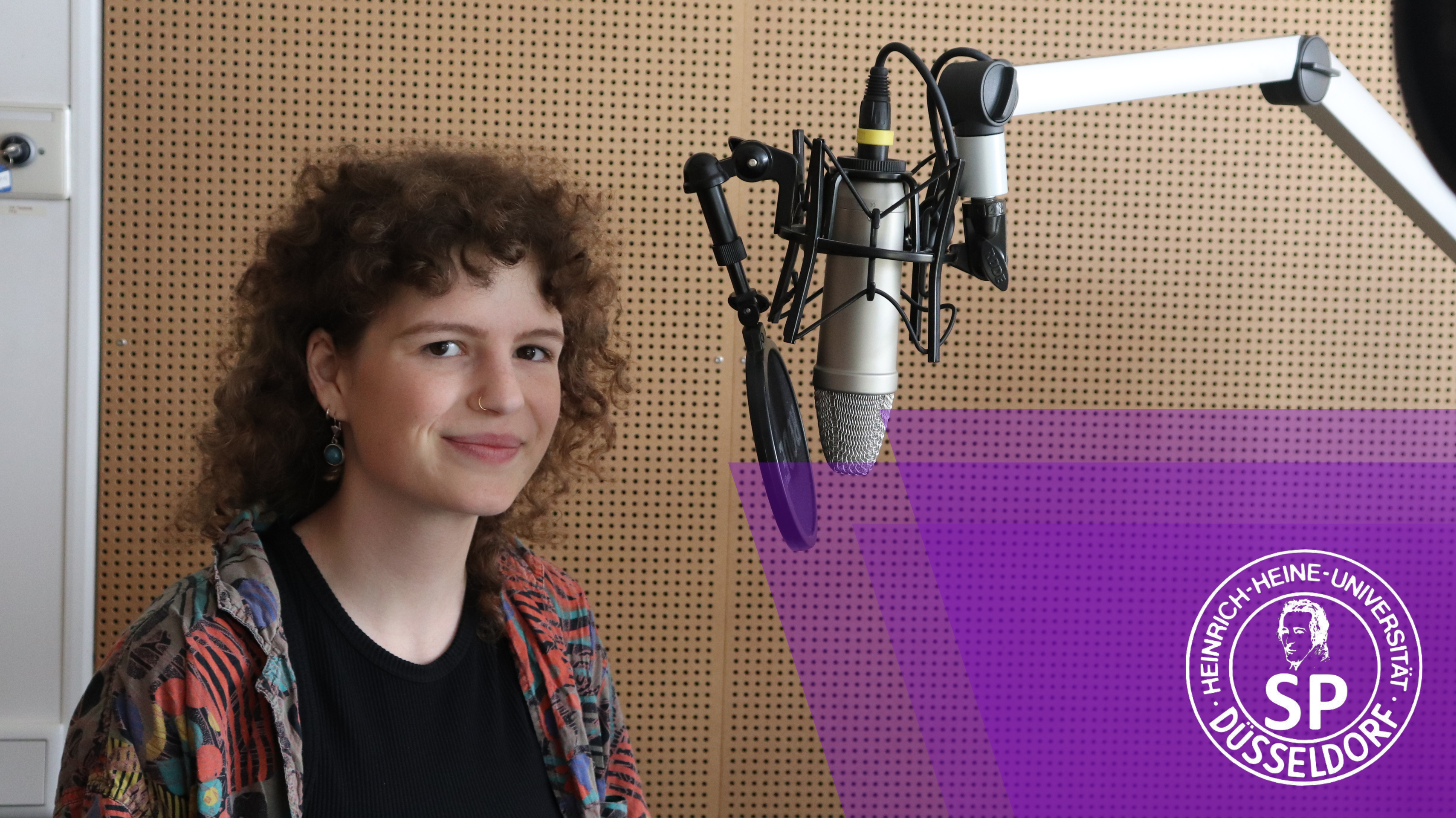 Lisa Schubert ist die Kandidatin für die Linke Liste (Foto: Anna Urban) Zu sehen ist eine junge Frau mit braunen Locken, die hinter einem Radiomikrofon steht