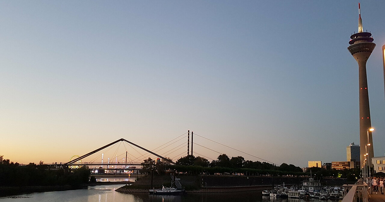 Zu sehen ist ein Sonnenuntergang am Rhein und der Rheinturm